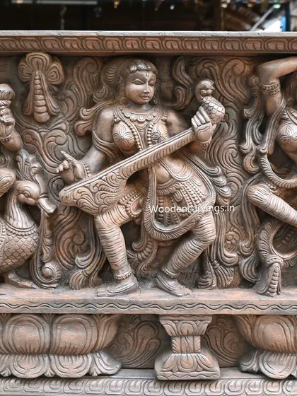 A detail of an Apsara playing a stringed instrument, showcasing the delicate hand positions and the intricate patterns carved into the wood.