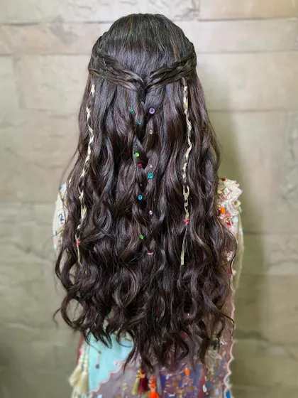 A detailed shot of the fun, bohemian hairstyle we created for garba night, with colorful beads and strings woven into the braids.