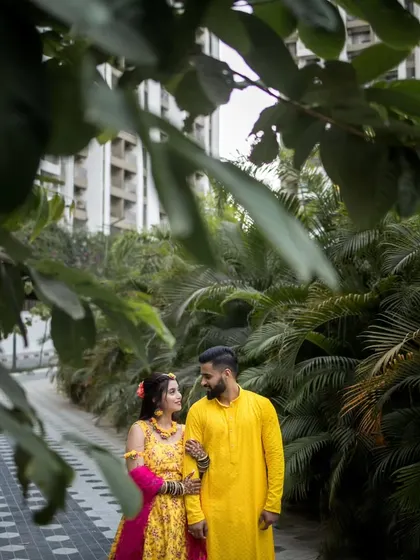 A creatively framed shot of the couple, using natural foliage to create a sense of intimacy and privacy.