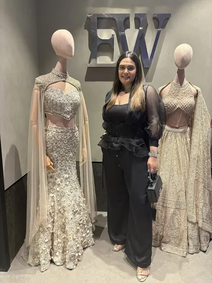 At the new Elisha Wadhwani store opening, standing next to her incredible couture creations. I wore her ultra-feminine ruffled black top to support the designer and showcase her detailed work.