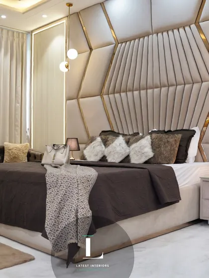 Another angle of the bedroom, focusing on the grand, custom-designed geometric headboard with gold metal inlays. The layered pillows and soft throws add to the luxurious and inviting feel.