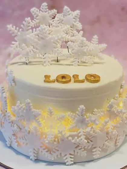 A closer view of the illuminated snowflake cake, showing the delicate sugar work.