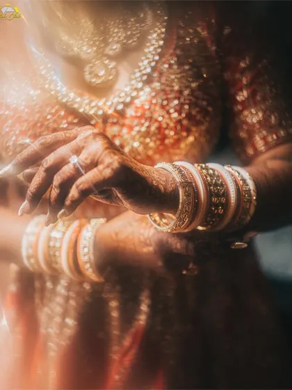 A close-up on the bride's hands, adorned with bangles and mehendi. This detail shot uses a prism effect to create a beautiful, glowing image that highlights traditional elements.