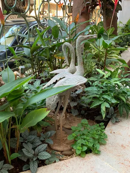 Another angle of the crane sculptures, showing how they integrate seamlessly with the surrounding plants and hardscaping.