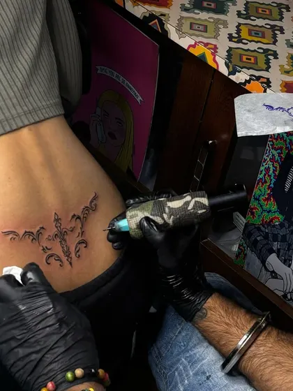 Inking a lower back tattoo. You can see the stencil and my setup in the background, showing the creative and professional environment of the studio.