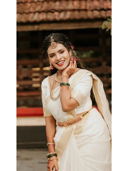 A radiant and happy portrait of the bride in her kasavu saree.