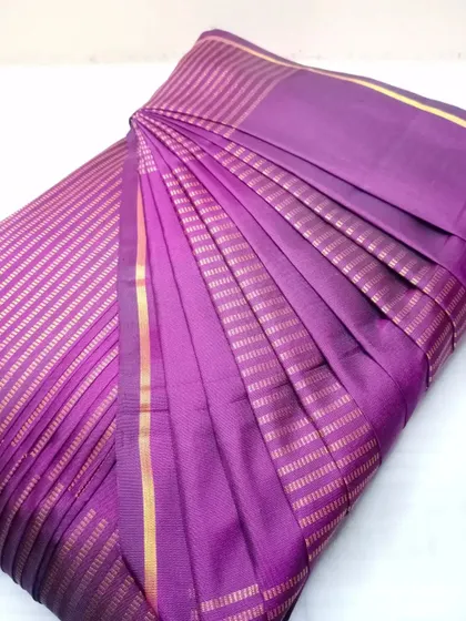 This purple saree with fine gold stripes is now perfectly pleated and folded. It's ready for a special occasion, saving you time and effort.