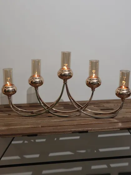The Vesper Quintet 5-tube candelabra in its full glory. Its graceful, intersecting arms and rose-gold finish create a captivating centerpiece for any dining table or console.