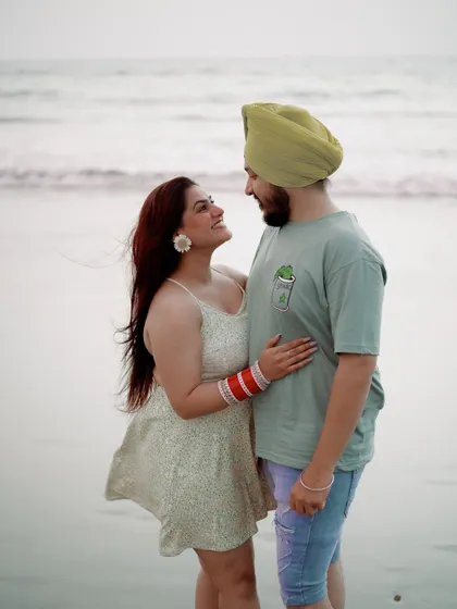 A candid moment of connection. The couple shares a look, lost in their own world, with the gentle waves of the sea behind them. This is what relaxed destination photography is all about.