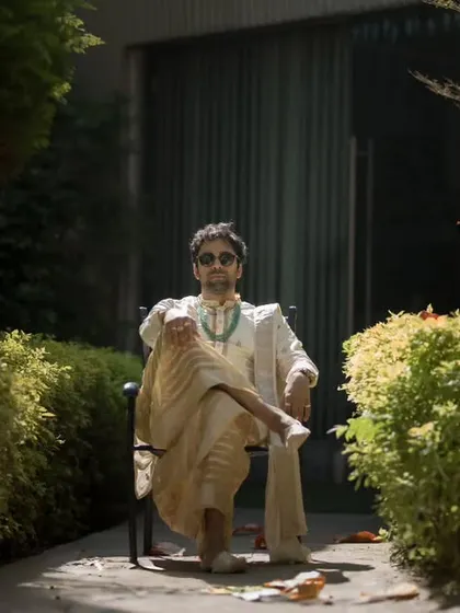 The groom, relaxed and stylish, enjoying a quiet moment in the sun before the festivities begin. This shot captures his cool confidence and personality.