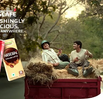 The main campaign image for Nescafé, showing the two friends enjoying a break. The styling reflects a carefree, adventurous spirit, perfect for the brand's "Anytime, Anywhere" message.