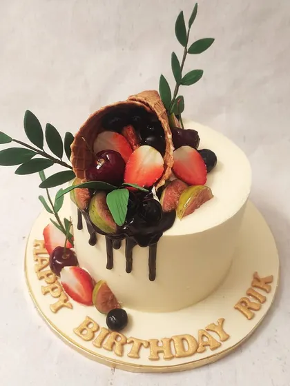 We celebrate nature's sweetness with this fresh fruit cornucopia cake. A waffle cone overflows with fresh strawberries, cherries, and figs, drizzled with rich chocolate, creating a vibrant and delicious design that is both rustic and elegant.