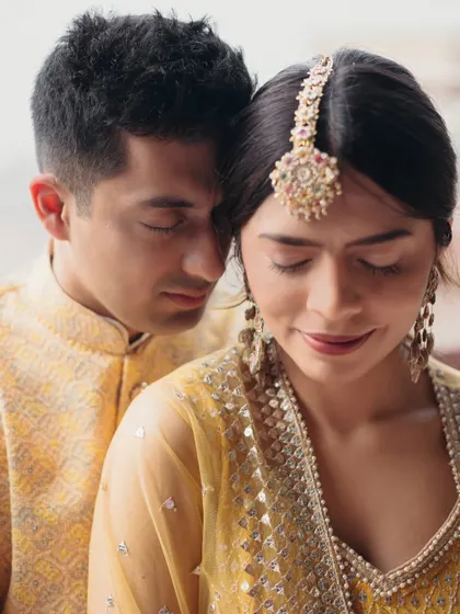 A tender close-up of the couple during their Haldi ceremony, their eyes closed in a moment of quiet affection.