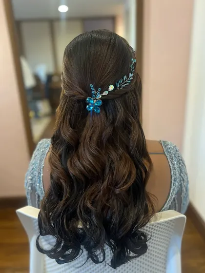 The blue accessory adds a lovely pop of color to this romantic half-updo, complementing the soft waves perfectly.