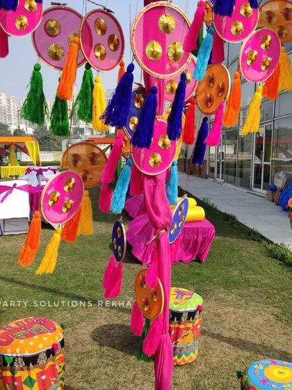 I love creating fun, interactive corners for guests. This outdoor Mehendi setup features colorful hanging tassels and hand-painted dholki-style stools, making for a perfect, Instagrammable photo opportunity.
