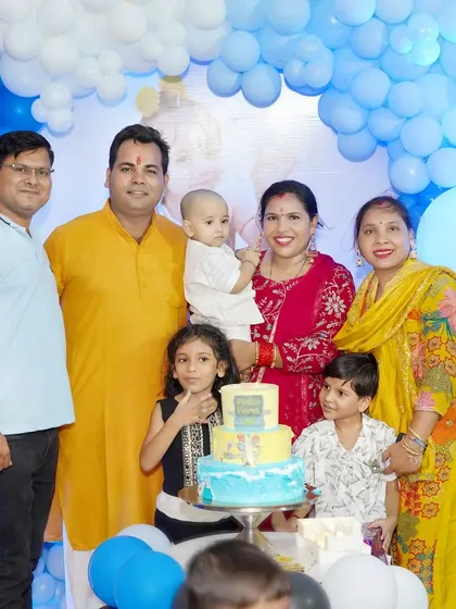 A large family group gathers for a photo around the birthday cake. We are experienced in organizing and photographing large groups at events.