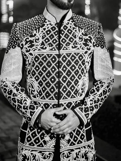 A detailed shot focusing on the intricate patterns of the hand-embroidered jacket. Every line and embellishment is carefully placed to create a harmonious and luxurious design.