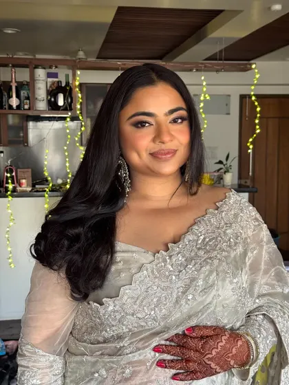 A close-up showcasing the bridal glow. The makeup is soft and luminous, with defined eyes and a gentle smile, perfectly capturing her happiness.