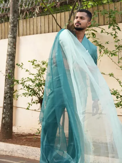 A profile shot with the sheer sash of the suit flowing in the breeze, creating a sense of movement and drama.