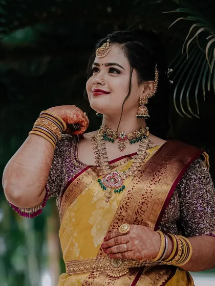 A confident and happy pose. Inchara's full jewellery set shines, showing how our pieces can make any special day even more memorable.