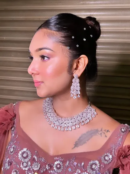 A sleek and modern bun, dotted with crystals for a touch of sparkle. This hairstyle is perfect for a glamorous reception or cocktail party look.