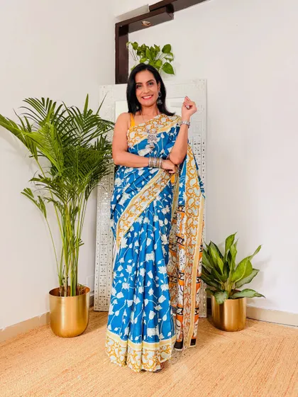 This blue Kalamkari print saree is so elegant. The yellow and white details on the border and pallu make it stand out. It's a beautiful piece for casual outings or work.