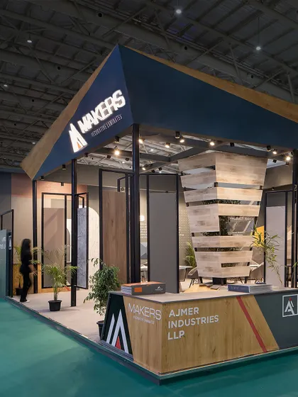 We designed this pavilion-like structure for Makers Laminate, using slender pillars to support an abstract roof. The main entrance and reception desk are clearly defined by the angled architecture and prominent branding.