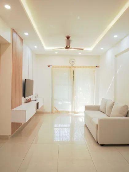 A full view of the minimalist living room, showcasing the clean lines of the furniture and the simple yet effective false ceiling design.