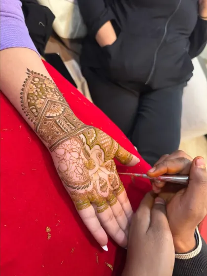 A behind-the-scenes shot of me carefully applying a traditional design. The precision and focus are key to creating a flawless result.