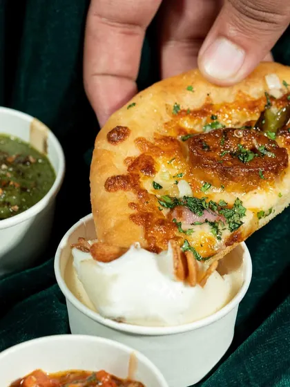 The perfect dip. This action shot captures the texture of the bread and the creaminess of the dip, creating a simple yet powerful image that stimulates the appetite.