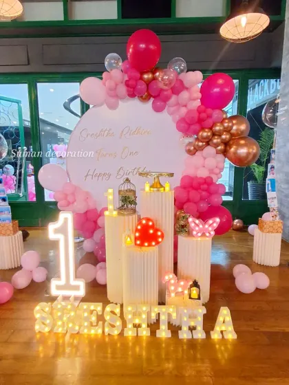 The full setup for Sreshtha's first birthday, showing all the elements including the personalized marquee name.