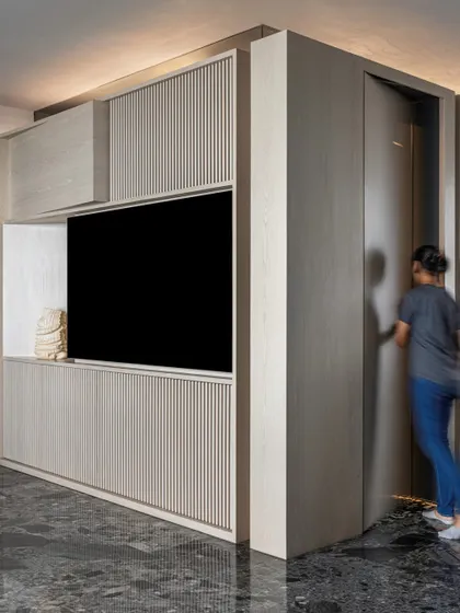 A person interacts with the sliding panel of the kitchen block in 'A Wedged Haus'. This shows the kinetic and functional aspect of the design, where parts of the monolithic object move to reveal or conceal functions.