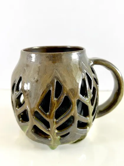 Another view of my double-walled leaf mug, showing the intricate details of the hand-carved pattern.