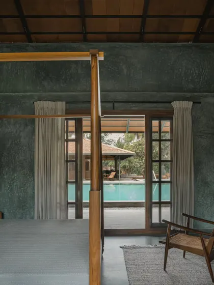 The walls of this bedroom in Villa Maati are finished with a dark, textured lime plaster. This traditional, breathable finish gives the walls a soft, tactile quality that cannot be achieved with paint.