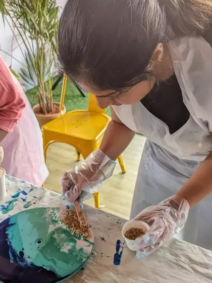 Adding sand to the shoreline of a resin beach clock. This is where you get to be creative with the landscape of your miniature beach.
