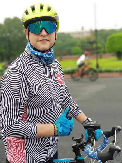 A stylish cyclist posing with his bike. Our members have great taste in both gear and fashion.