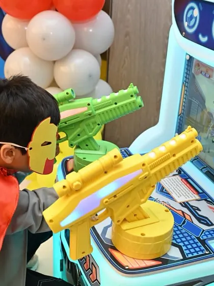 A little Iron Man taking aim at the shooting arcade game.