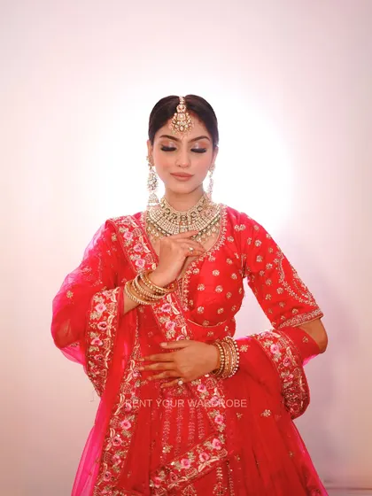 Another portrait in the red and pink lehenga, capturing a moment of quiet grace.
