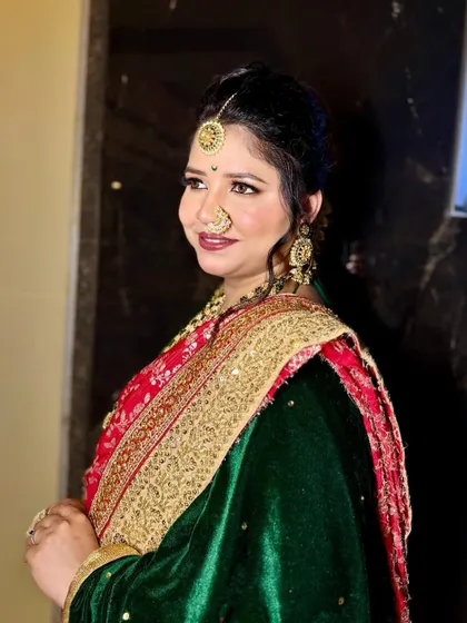 A profile of a stunning Maharashtrian bride. The makeup highlights her features with a classic winged liner and a bold lip, paired with traditional gold jewelry.