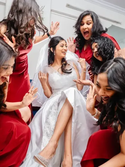 The bridesmaids surround the bride, their excited expressions making for a fun and lively group shot.