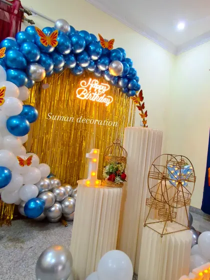 A close-up of the butterfly theme decor, showing the light-up number '1' and the detailed props on the cake stands.