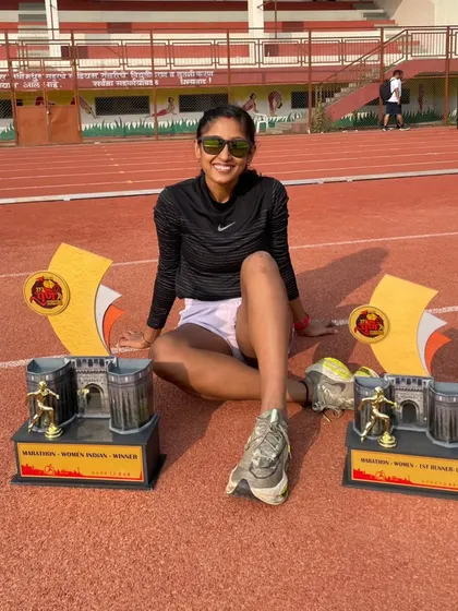 The spoils of victory. Sitting on the track with my first and second place trophies from the Pune International Marathon.