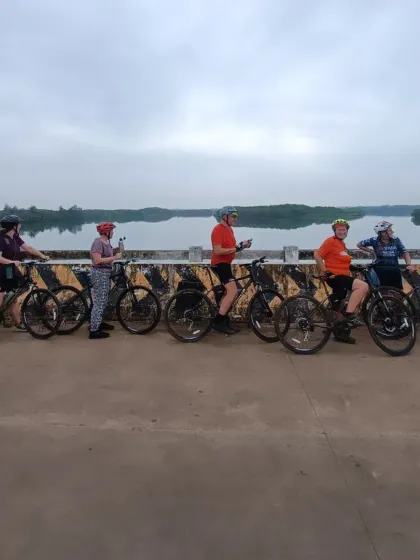 A group of our riders taking a photo break on a bridge over the calm backwaters. The West Coast ride is filled with picturesque landscapes, from lush forests to tranquil waterways.