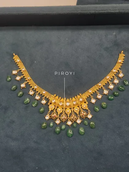 The 'piroyi' or beadwork stage of a necklace transformation. This shows the intricate process of adding pearls and emeralds to give an old piece a fresh and colorful new look.