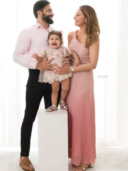 A party of three! This stylish family portrait is full of laughter and love. The little girl's joyful expression is the centerpiece of this beautiful image.