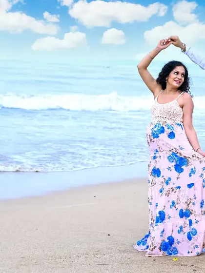A dance on the sand. This joyful, candid moment captures the happiness and excitement of the expecting couple during their relaxed and fun beach maternity session.