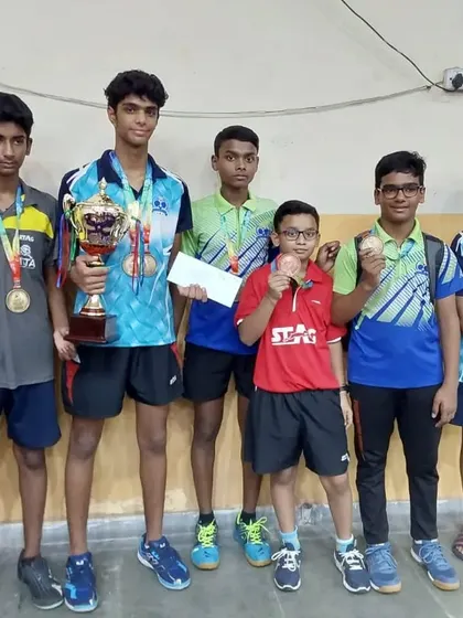 Our team of young champions. This group of players showcases their medals and trophies after a successful tournament run, highlighting our strength in team events.