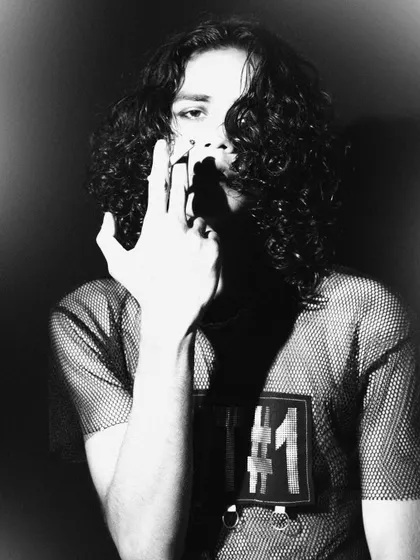 An edgy, high-contrast black and white shot. The pose and styling create a rebellious, rock-and-roll vibe for a fashion portfolio.