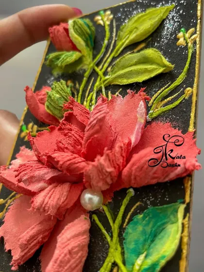 A close-up of a rectangular fridge magnet with a single, detailed pink flower on a black background. The pearl in the center adds a perfect finishing touch.