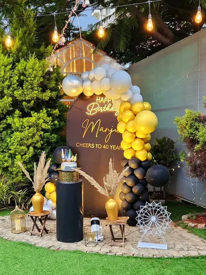 A stylish 40th birthday celebration in a garden. The black, gold, and silver color scheme gives it a sophisticated and modern feel.